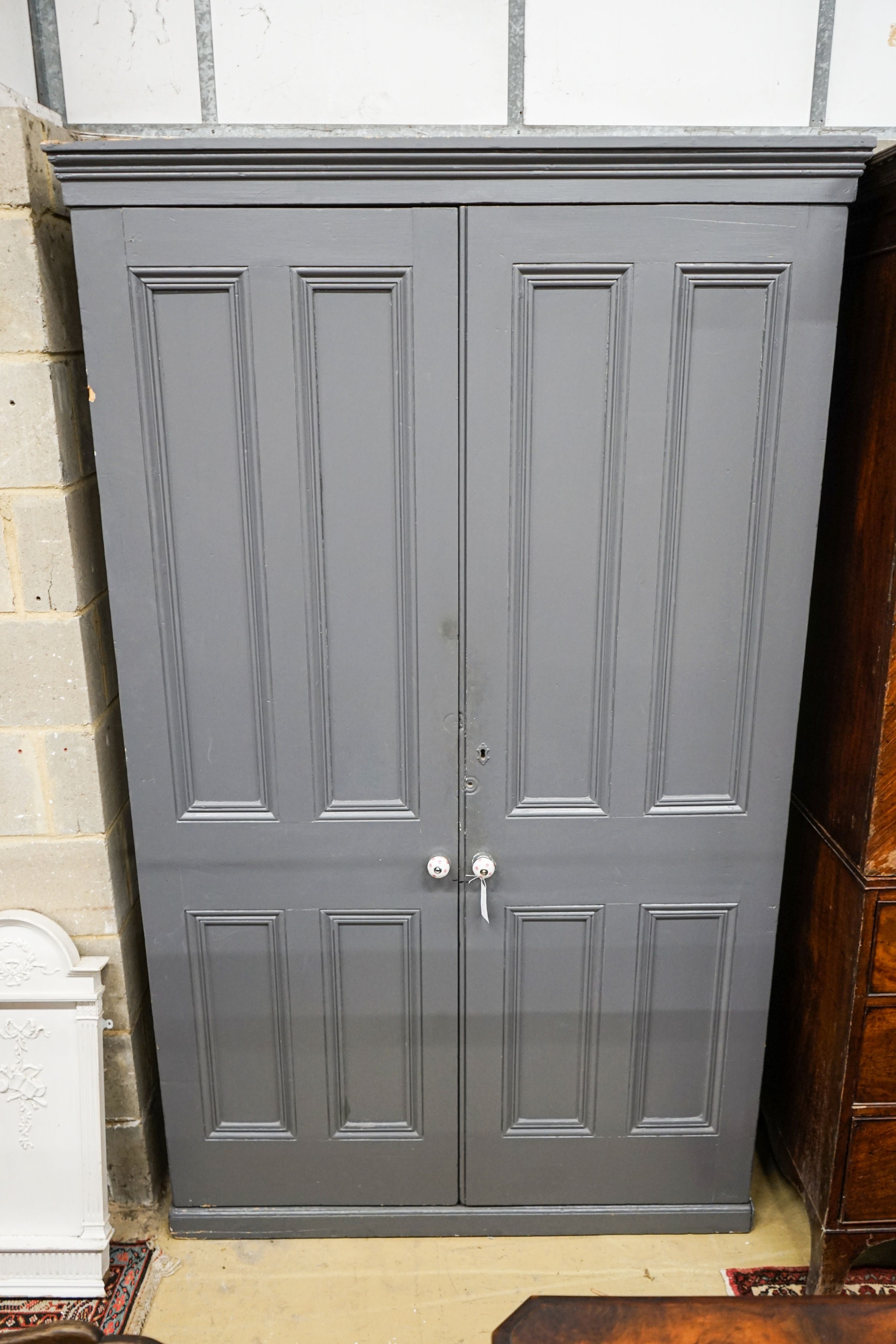 A Victorian painted panelled pine two door housekeeper's cupboard, width 130cm, depth 40cm, height 214cm